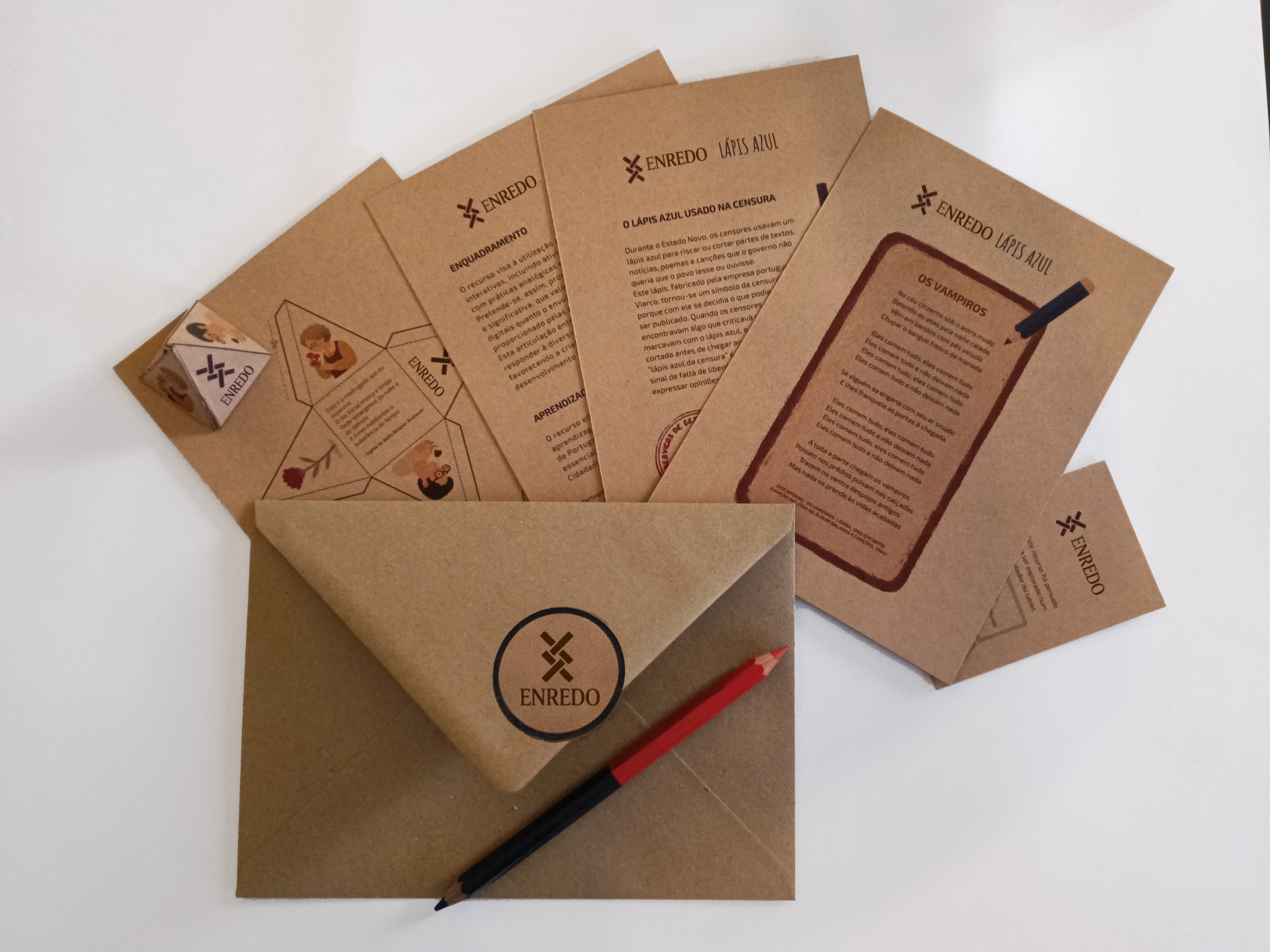 Materiais do kit ENREDO Lápis Azul abertos sobre envelope kraft